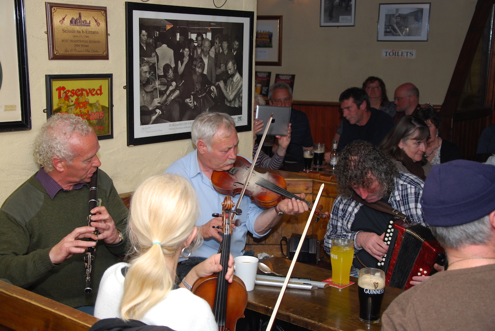 traditional Irish music session - A group of musicians, playing accordion, fiddle, flute playing in a pub session in Doolin County Clare